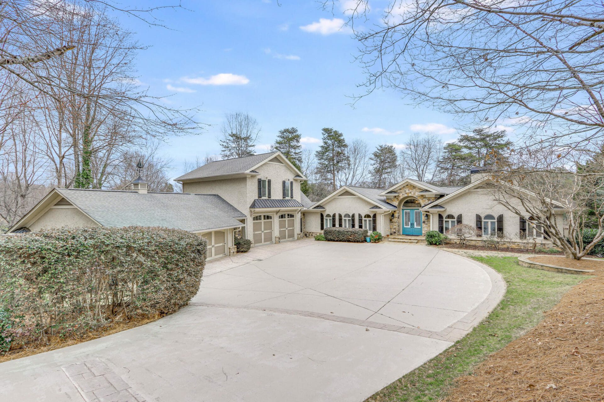 Large ranch style home with teal front door on Lake Lanier