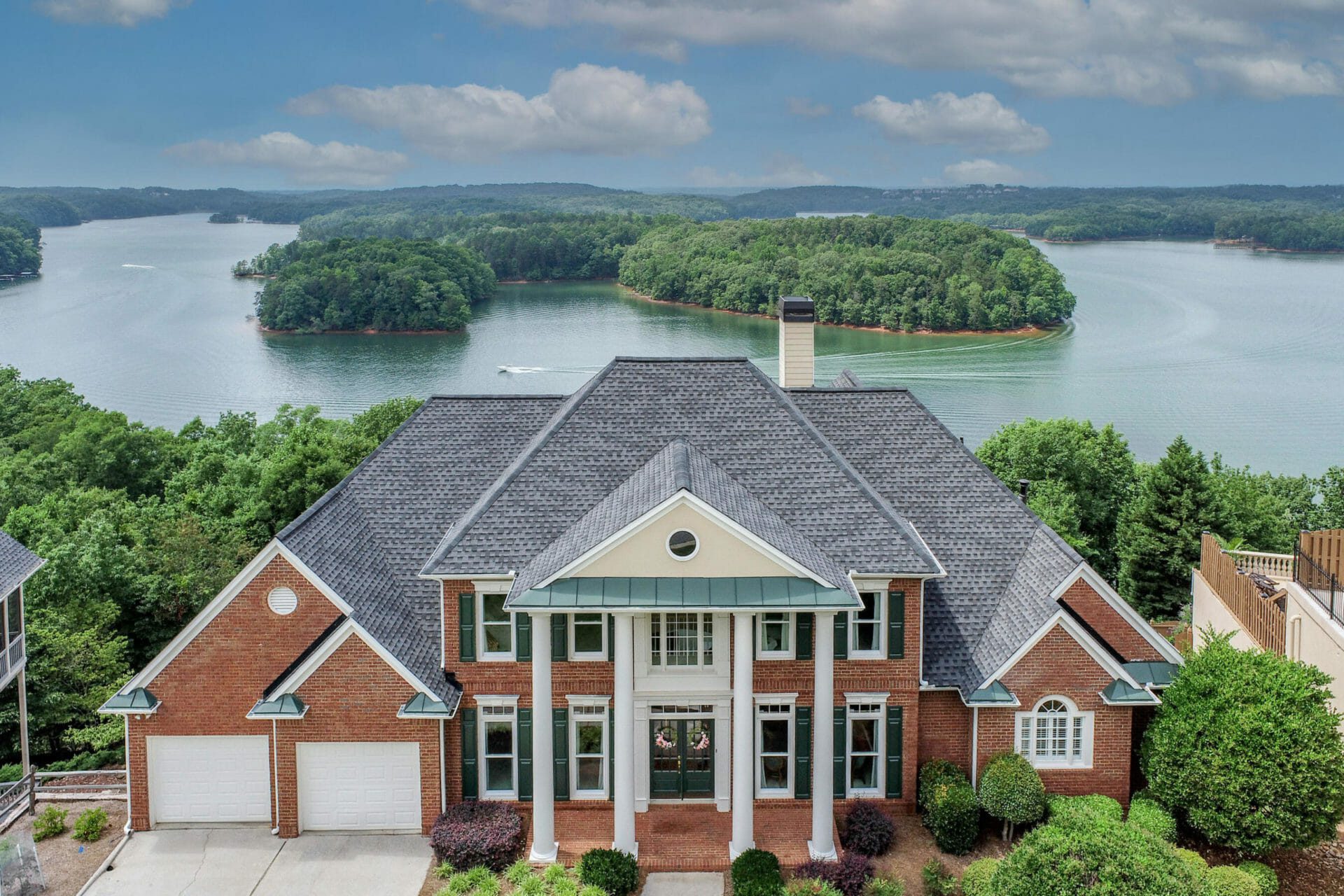 Large ranch style home with columns with view of lake on Lake Lanier
